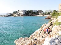 Салоу, пляж Капеланос: местные на закидушки и рыба под скалами