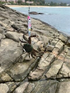 Таиланд, пляж Карон: морская рыбалка с камней на отливе у берега в сложных волнах Пхукета
